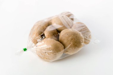Beyaz arka planda şeffaf plastik torba içinde Shiitake mantarı