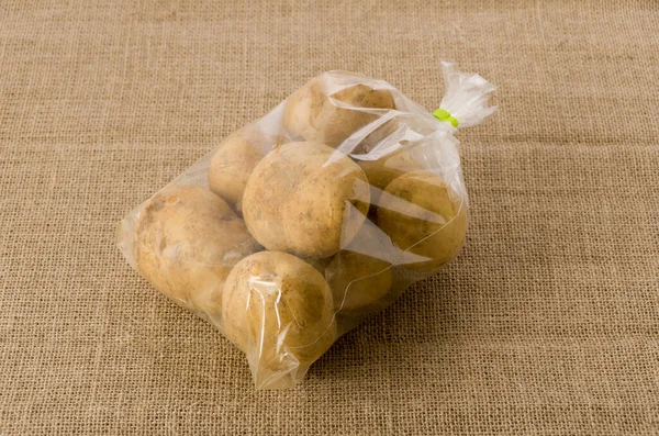Kahverengi kağıttan arka planda plastik poşette patates 
