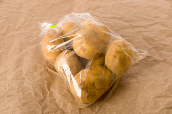 Potatis Plastpåse Brunt Papper Bakgrund — Stockfoto