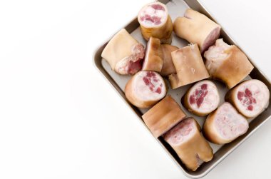 Beyaz arka planda alüminyum tepside taze çiğ domuz ayağı.