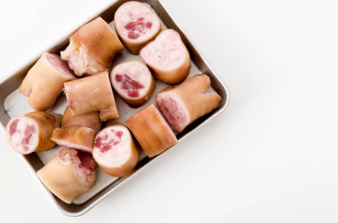 Beyaz arka planda alüminyum tepside taze çiğ domuz ayağı.