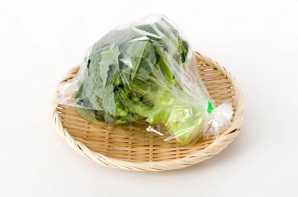 Frischer Brokkoli Transparenter Plastiktüte Auf Einem Bambussieb Auf Weißem Hintergrund — Stockfoto