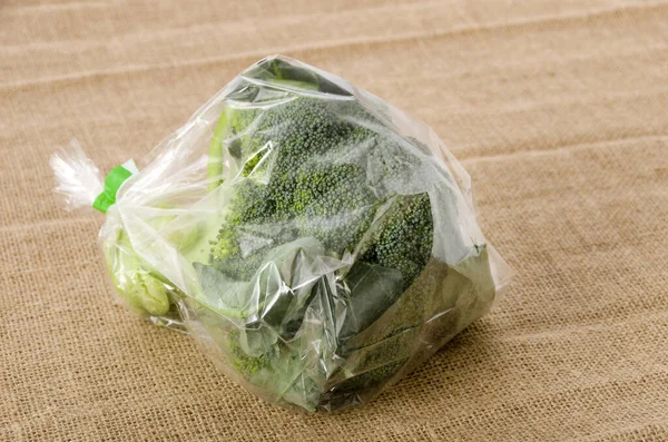 fresh broccoli in transparent plastic bag on  burlap