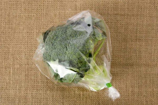 fresh broccoli in transparent plastic bag on  burlap