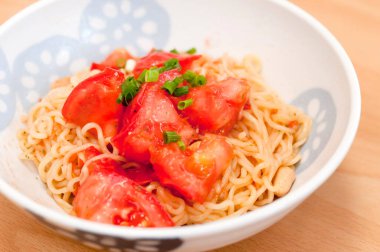 Kızarmış yakisoba şehriyesi, domatesli, fıstıklı, ahşap masada.. 