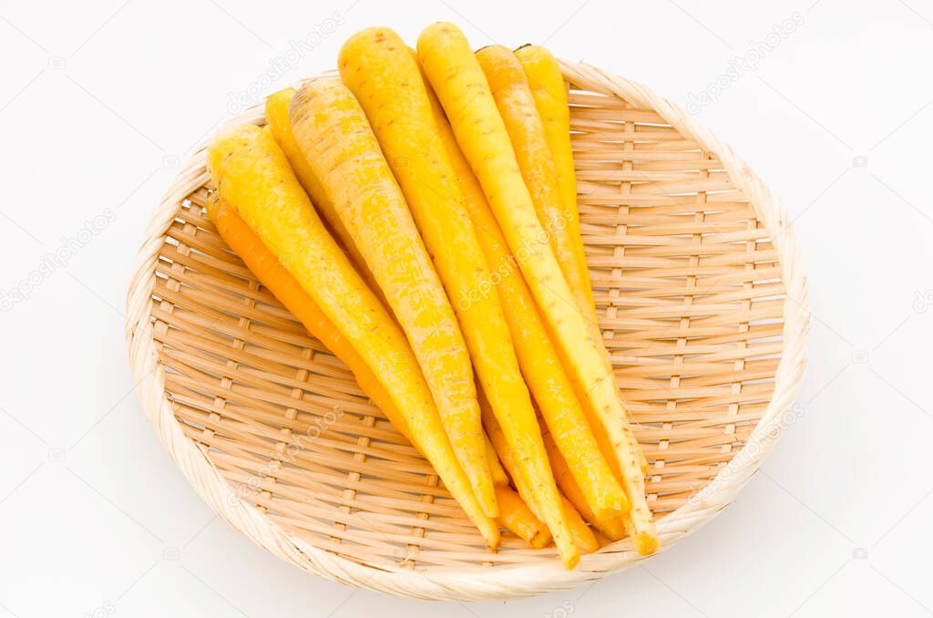 Shimaninjin, type of yellow carrot grown in Okinawa, yellow carrot on bamboo colander white background