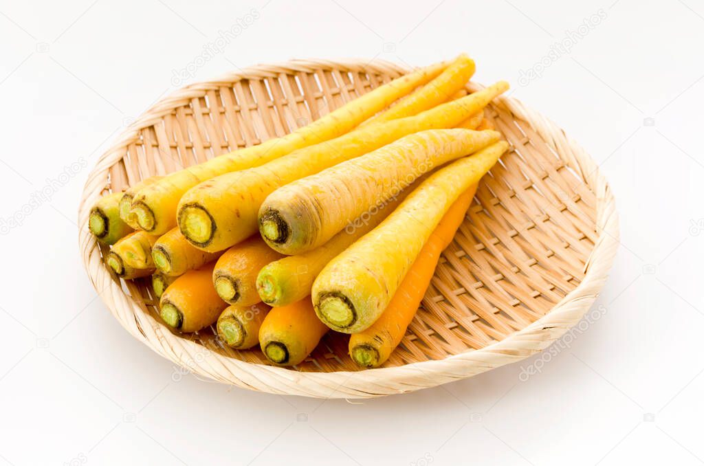 Shimaninjin, type of yellow carrot grown in Okinawa, yellow carrot on bamboo colander white background