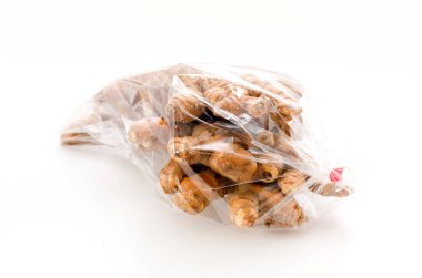 Beyaz zemin üzerinde plastik poşette yabani zerdeçal (Curcuma aromatica salisb)