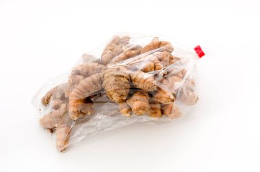 Beyaz zemin üzerinde plastik poşette yabani zerdeçal (Curcuma aromatica salisb)