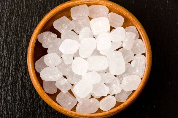 Açúcar Rocha Branco Uma Tigela Madeira Redonda Placa Pedra Preta — Fotografia de Stock