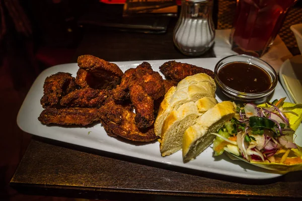 Asas de chiken grelhadas alemãs, molho de churrasco, pão e salada — Fotografia de Stock