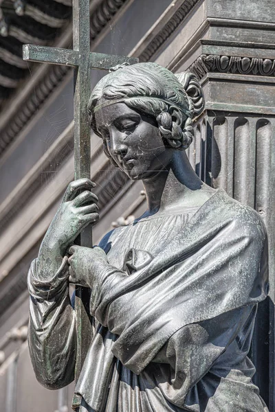 Alte Metallstatue einer sinnlichen Frau als Gebet mit Kreuz und — Stockfoto