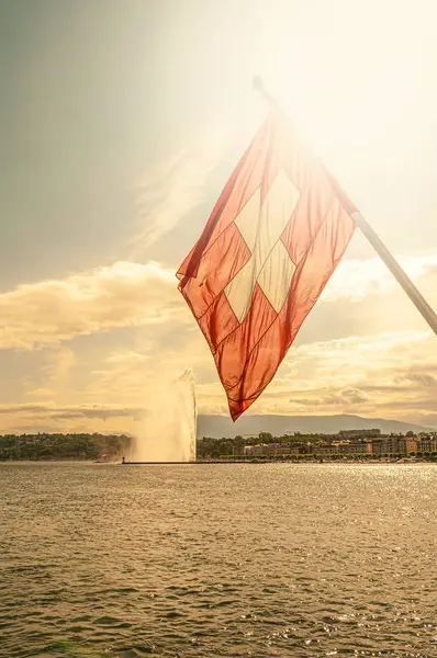 Swiss flag, Leman lake at sunset and a super Jet fountain in the — Stock Photo, Image
