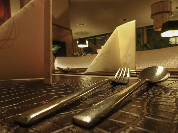 Couverts de salle à manger solitaires (cuillère et fourchette) reposent sur la table dans un faible — Photo