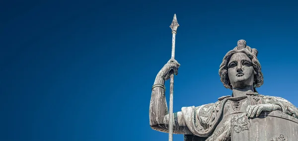 Banner mit oberer Statue einer Kriegerin mit Schild und Turmspitze — Stockfoto