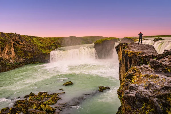 Poderosa cachoeira Godafoss no belo pôr-do-sol vermelho com uma solidão — Fotografia de Stock