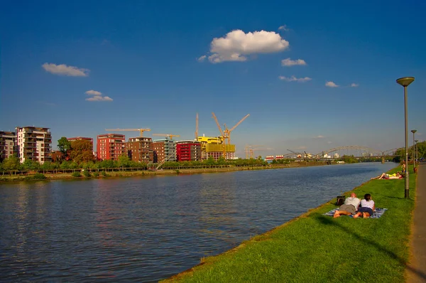 Mensen die zonnebaden en rusten aan de oever van de Main rivier met ne — Stockfoto