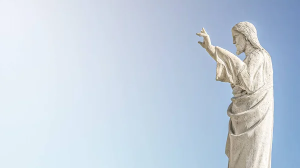 Banner med en staty av Jesus Kristus som ber vid kyrkan No — Stockfoto