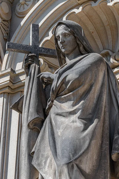 Antigua estatua de una mujer con cruz en el edificio histórico central — Foto de Stock