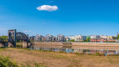 Magdeburg şehir merkezindeki yeni binalar ve eski metal demiryolu köprüsü Elbe nehir kıyısı, Almanya, güneşli bir gün, mavi gökyüzü