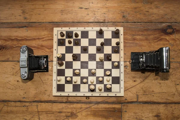 ahşap tahtasında satranç oynayan iki vintage kameralar bazı ayarla