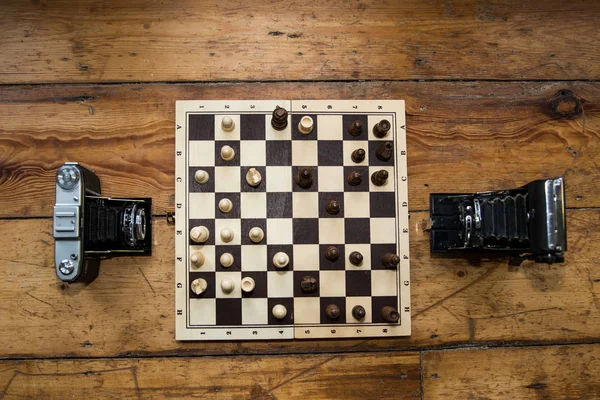 ahşap tahtasında satranç oynayan iki vintage kameralar bazı ayarla