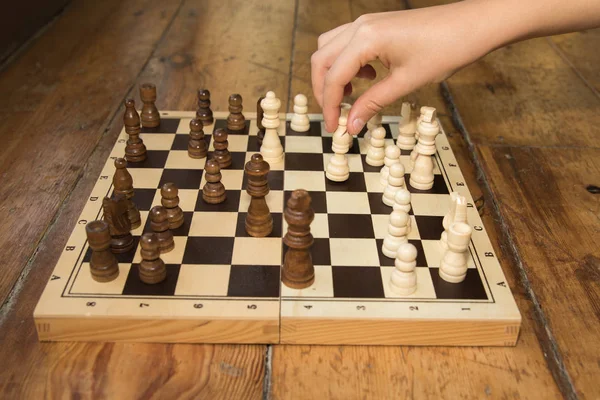 Una sola mano jugando al ajedrez en un tablero de madera — Foto de Stock