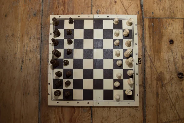 Chess on a wooden board set on some wooden floor — Stock Photo, Image