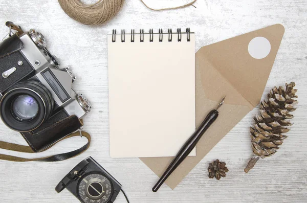 Notebook em branco com caneta inc e câmera retro na mesa de madeira . — Fotografia de Stock