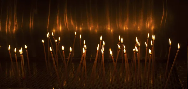 Kerk kaarsen gloeien in het donker — Stockfoto