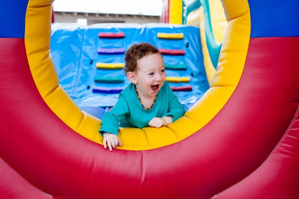 Criança feliz espreitando no trampolim — Fotografia de Stock