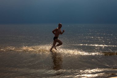 Deniz kenarında adam çalışır