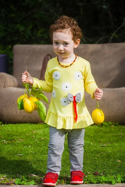 Söt liten knatte med citroner — Stockfoto