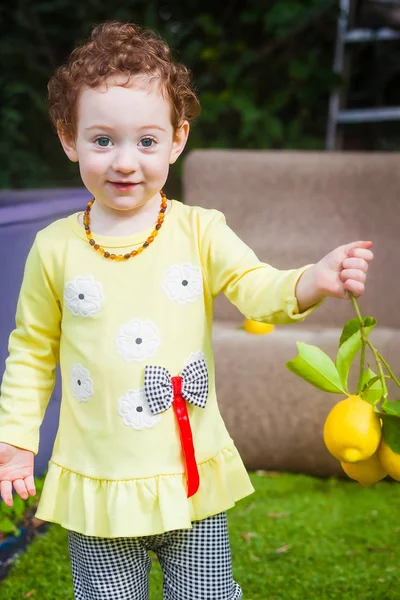 Close portrait of toddler with lemons — Stock Photo, Image