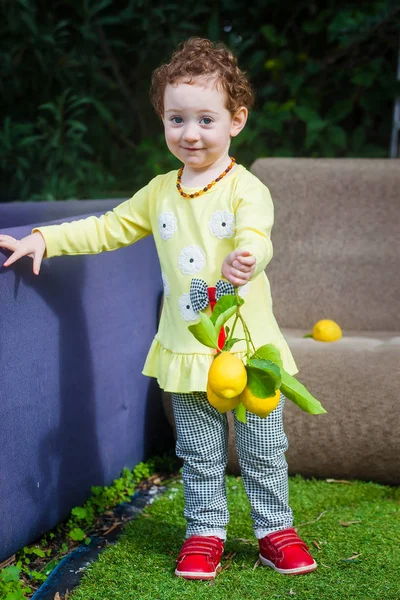 Kızıl saçlı yürümeye başlayan çocuk kızla limon — Stok fotoğraf