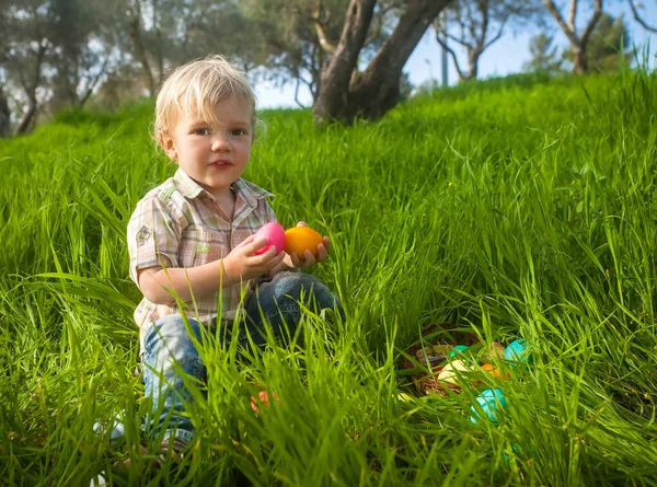 Cute toddler with Easter eggs in the grass — Stock Photo, Image