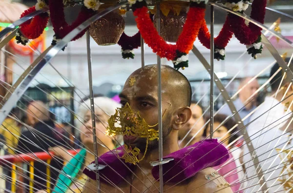 7 Feb 2012, Singapore: A male devotee carries a kavadi with face and body piercings as part of the annual Thaipusam festival in Singapore