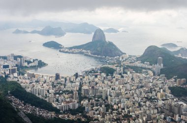 Rio de Janeiro 'nun İsa' dan görüntüsü Kurtarıcı heykeli, Botafogo Körfezi 'nin sonundaki Sugarloaf Dağı.