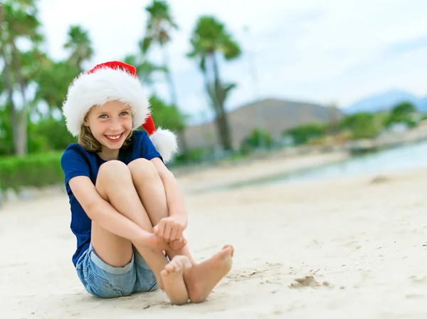 Glückliches kleines Mädchen am Strand. Weihnachts- und Neujahrsurlaubskonzept. Raum für Ihren Text. — Stockfoto