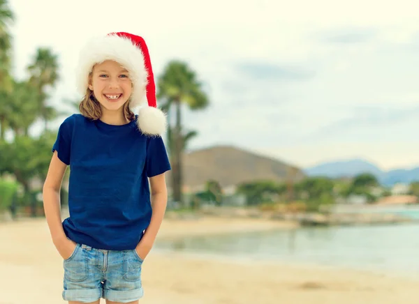 Boldog kis lány a strandon. Karácsonyi és újévi vakáció koncepció. A szöveg tér. — Stock Fotó
