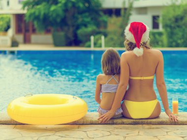 Küçük kız ve annesi sıcak ülkede Noel kutluyor.