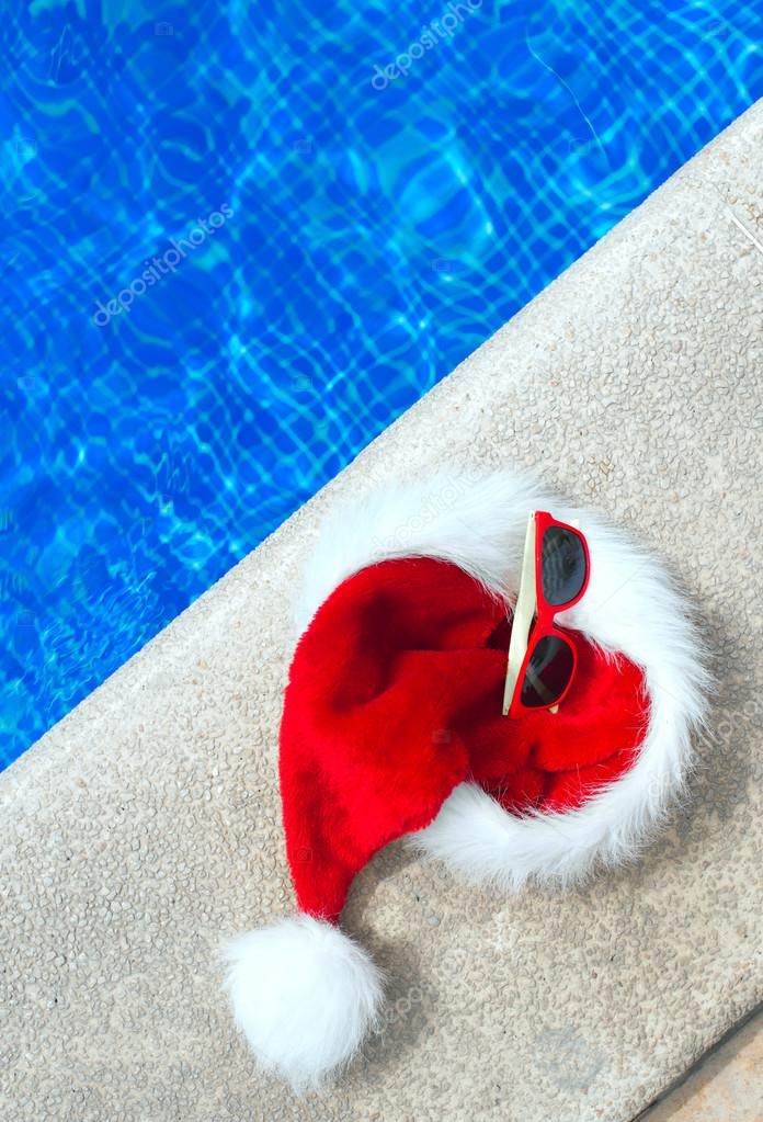 Superioriteit musical Weigeren Rode kerst hoed en zonnebril in de buurt van het zwembad. Plaats voor  tekst. ⬇ Stockfoto, rechtenvrije foto door © mproduction #126846144