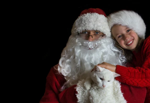 Glückliches kleines Mädchen mit Katze und Weihnachtsmann. Raum für Text. — Stockfoto