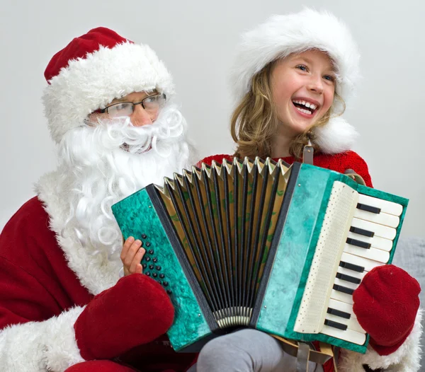 Santa Claus y la niña jugando acordeón en Navidad . — Foto de Stock