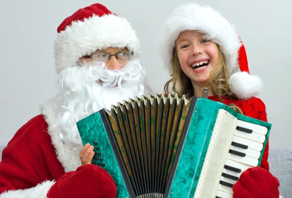 Noel Baba ve küçük kız akordeon Noel'de oynamaktan. — Stok fotoğraf