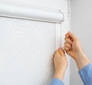 Pencerelerde kaset silindir panjurlarını test eden adam.