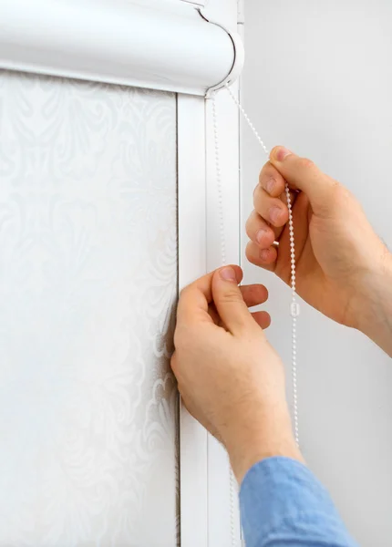 Man testing cassette roller blinds on windows. — Stock Photo, Image