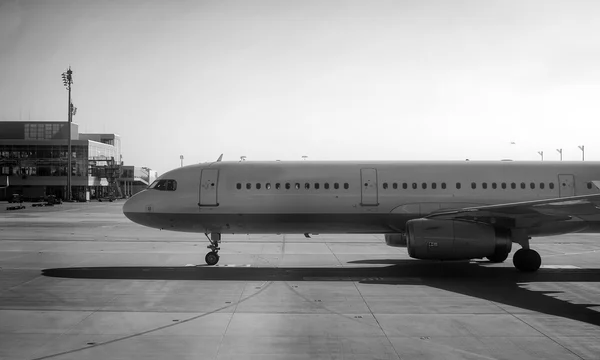Avión de pasajeros dirigiéndose al aeropuerto. Blanco y negro . — Foto de Stock
