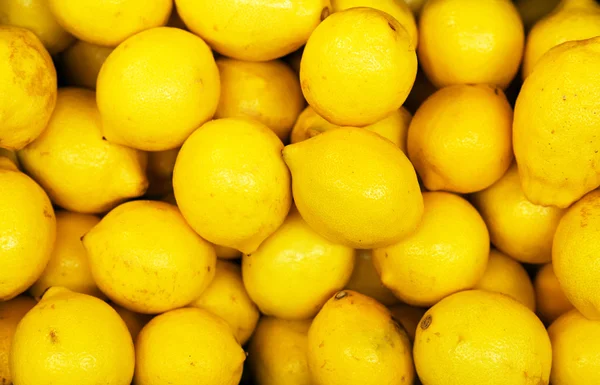 Lot of bright yellow lemons in supermarket. — Stock Photo, Image