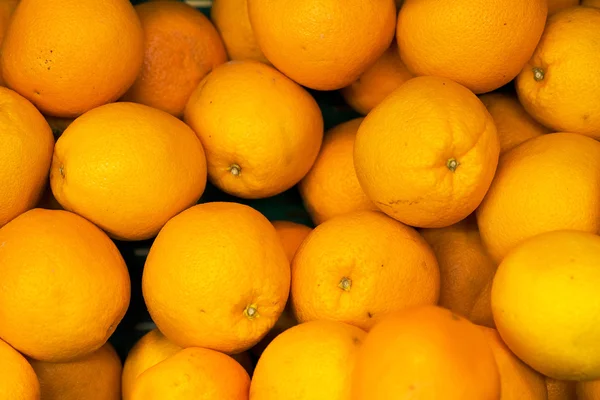 Massor av ljusa apelsiner i snabbköp. — Stockfoto